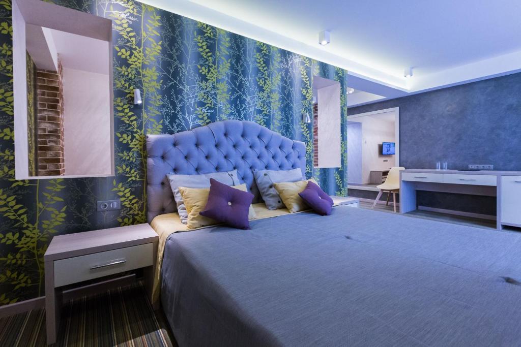 ソチにあるHotel Talismanのベッドルーム1室(大型ベッド1台、青いヘッドボード付)