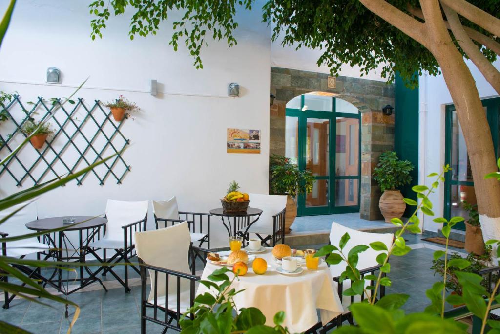 a patio with tables and chairs with oranges on them at Golden Sun in Hersonissos