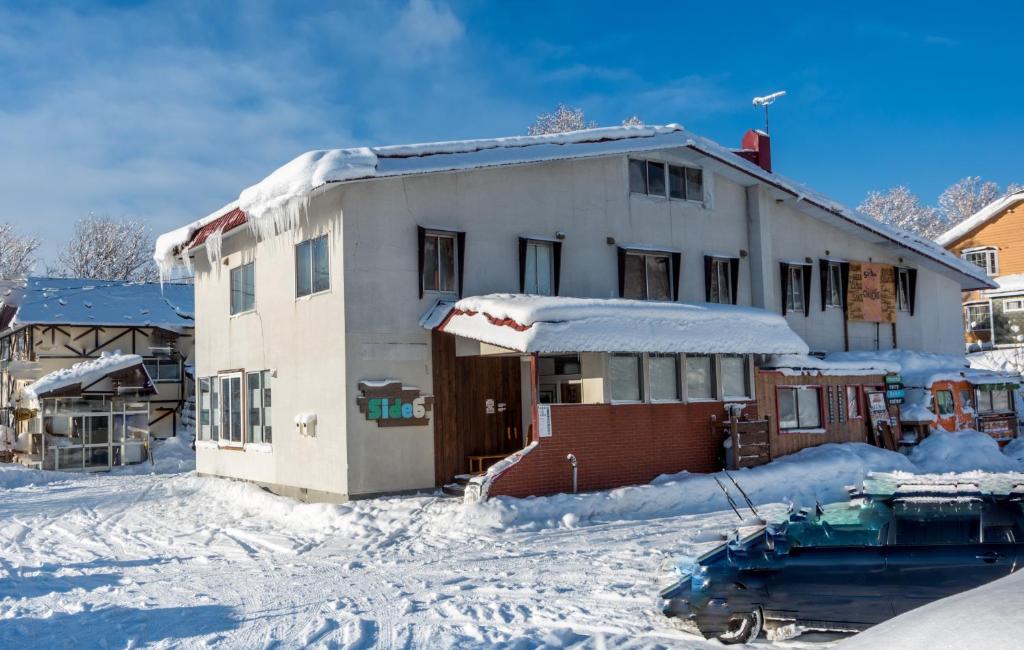 a house is covered in snow with snow at Niseko Side 6 in Niseko