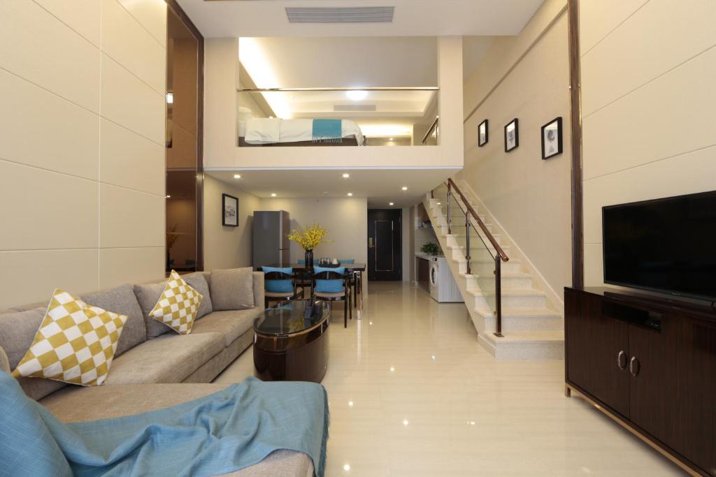 a living room with a couch and a television at WAIFIDEN Duplex Hotel Apartment Zhongyong Jinyu Branch-Free shuttle bus during the Canton Fair in Guangzhou