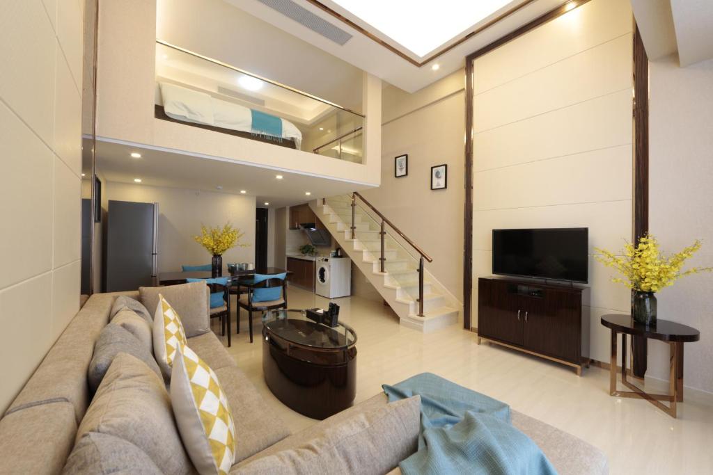a living room with a couch and a tv at WAIFIDEN Duplex Hotel Apartment Zhongyong Jinyu Branch-Free shuttle bus during the Canton Fair in Guangzhou