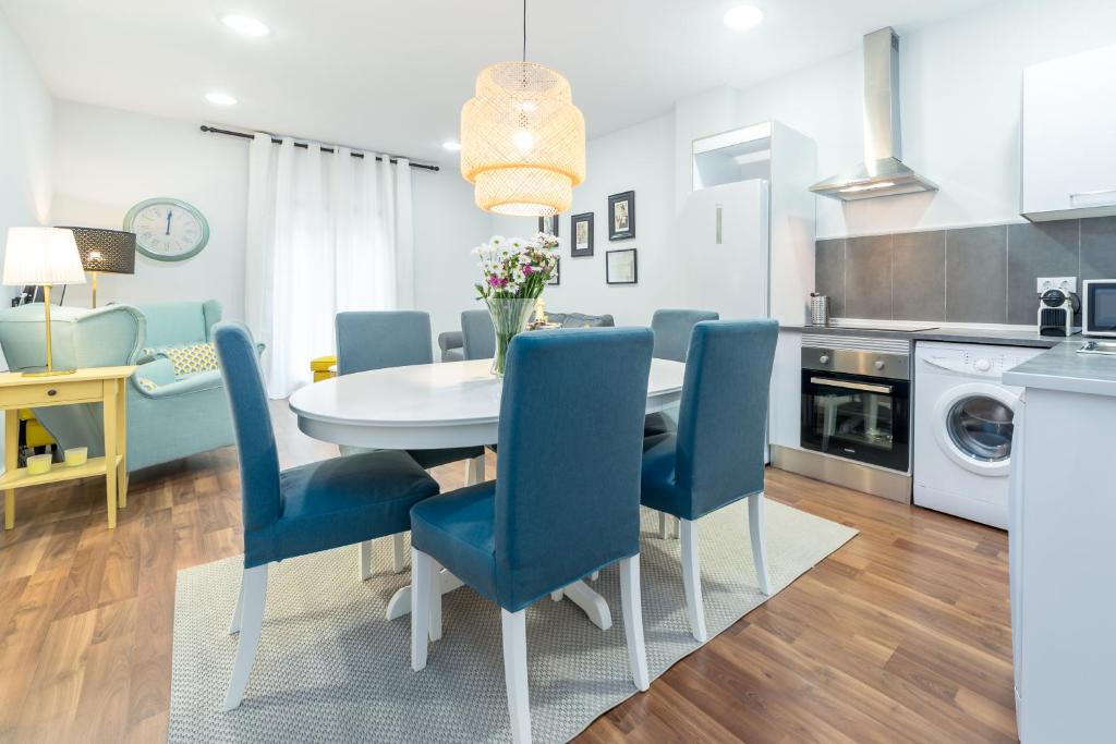 une cuisine avec une table à manger et des chaises bleues dans l'établissement La Bombonera del Turia, à Valence