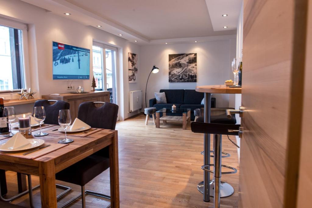 a dining room with a table and a living room at Appartement Central in Kitzbühel