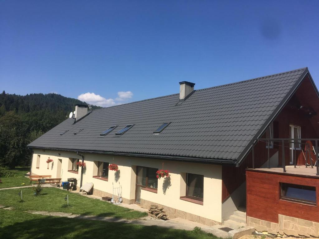 uma casa com um telhado preto em cima em Powroźnik 94 em Muszyna