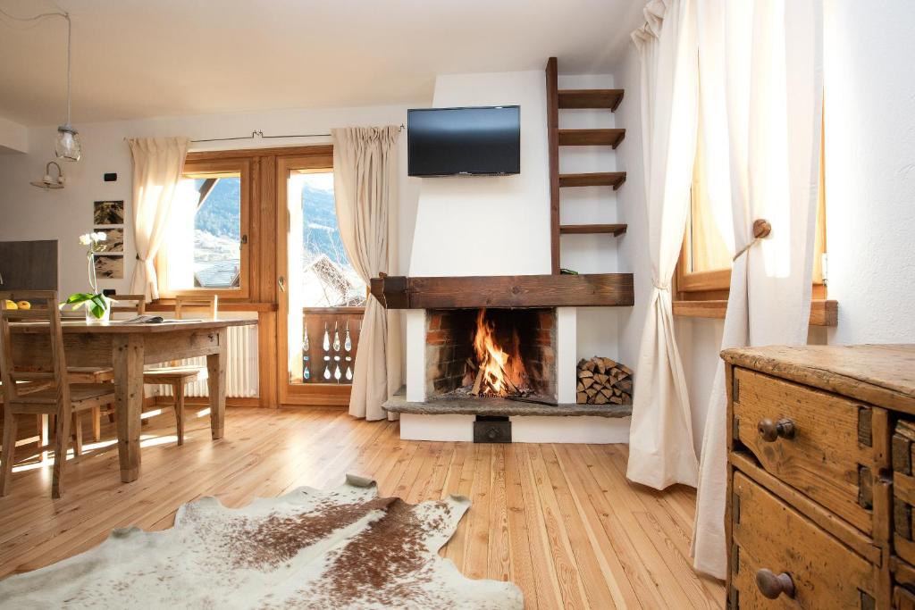 a living room with a fireplace and a dining room table at Casa Melide 2 in Bormio