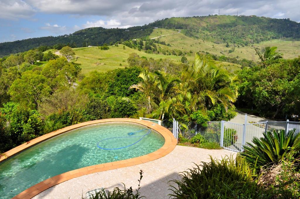 a swimming pool with a view of a mountain at Highwood Park B&B Guest Lodge in Maleny