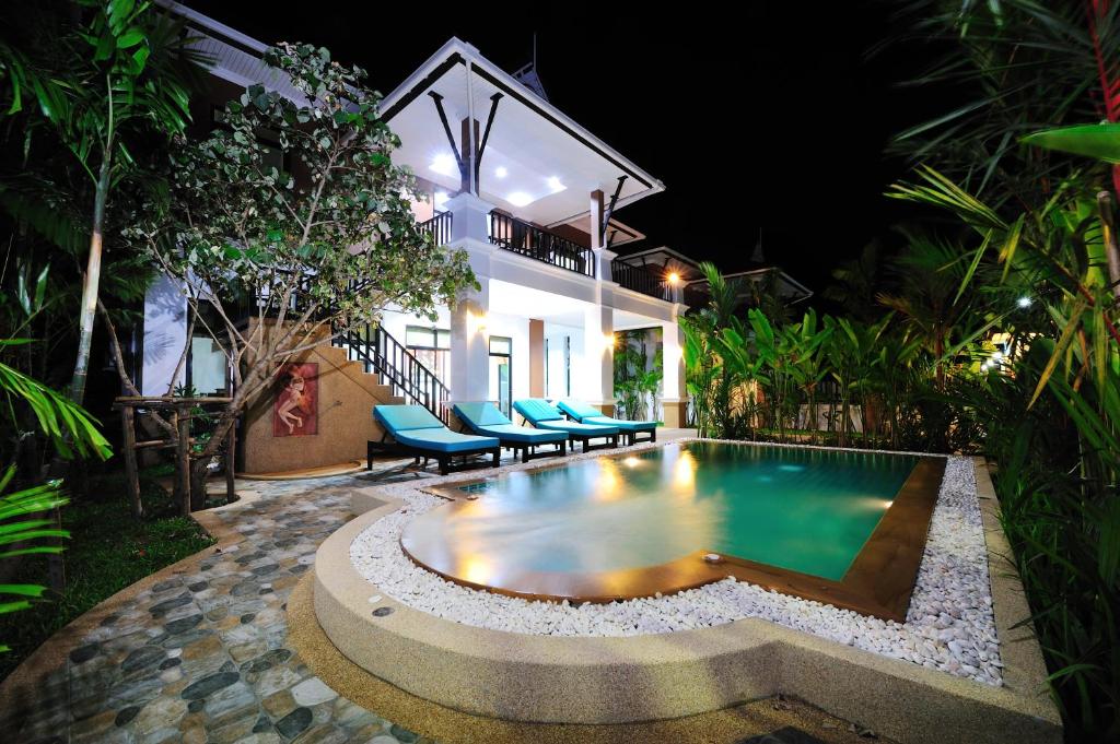 a swimming pool in front of a house at night at Baan Narakorn Villa in Ao Nang Beach