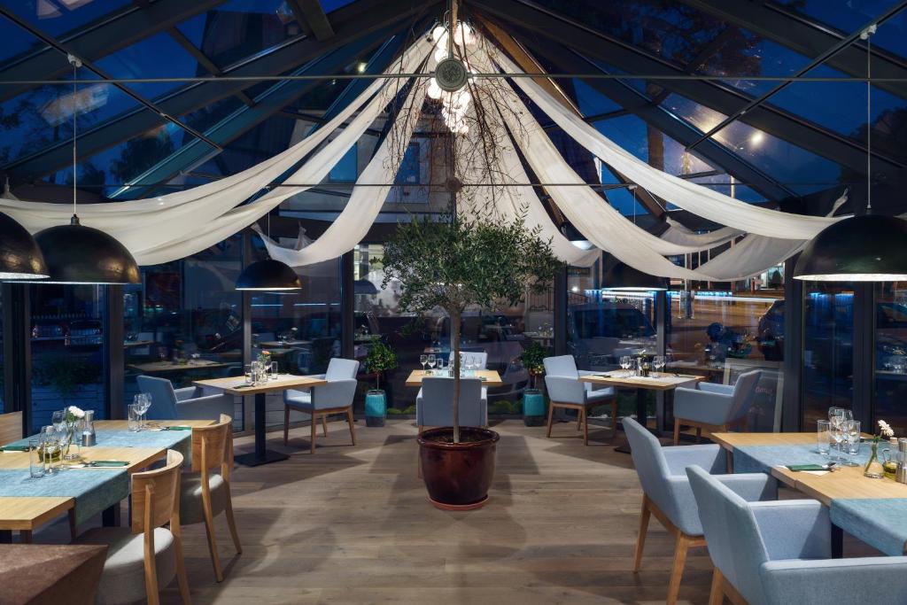 a restaurant with tables and chairs and a ceiling at Villa Zagórze in Rumia