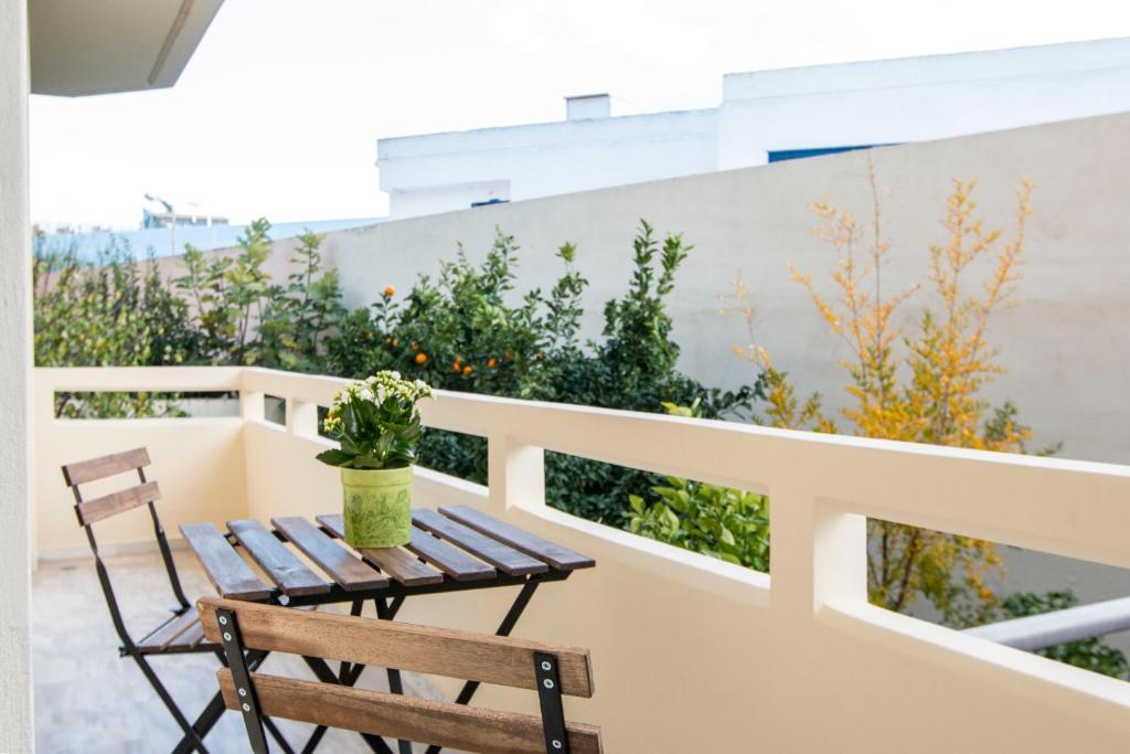 balcón con mesa de madera y 2 sillas en Krystal Apartment, en Atenas