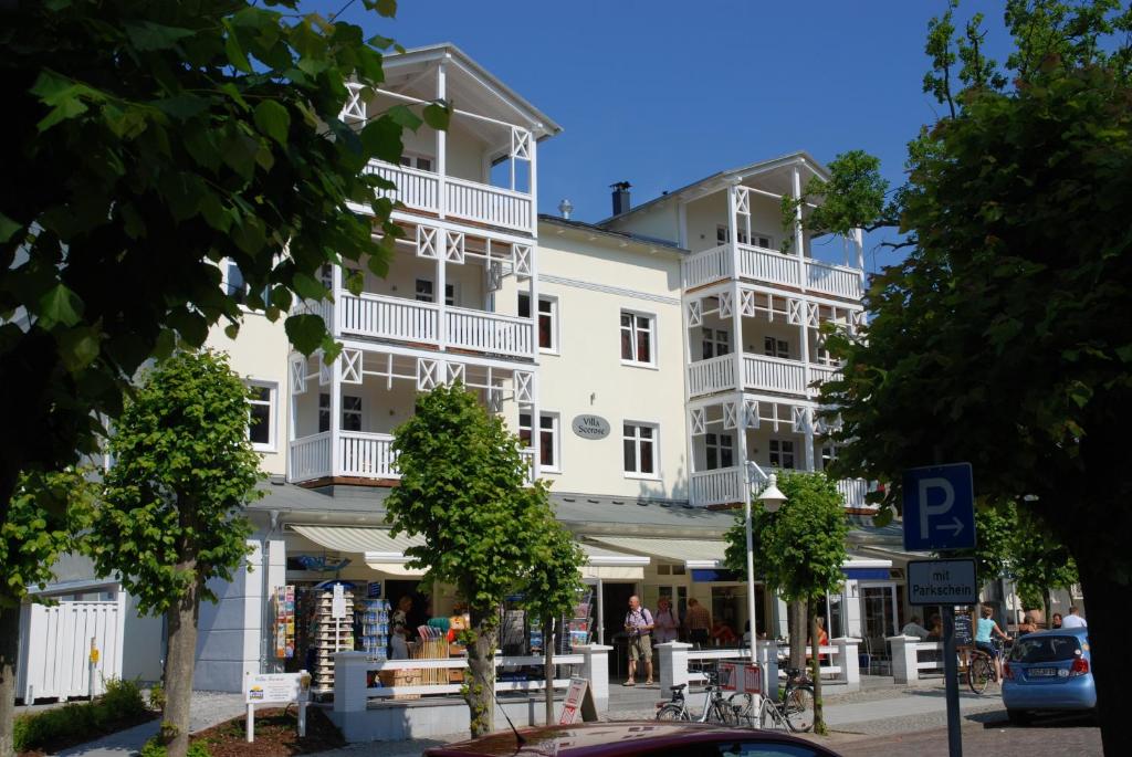 ein großes weißes Gebäude mit weißen Balkonen auf einer Straße in der Unterkunft Villa Seerose - Appartement 01 in Ostseebad Sellin