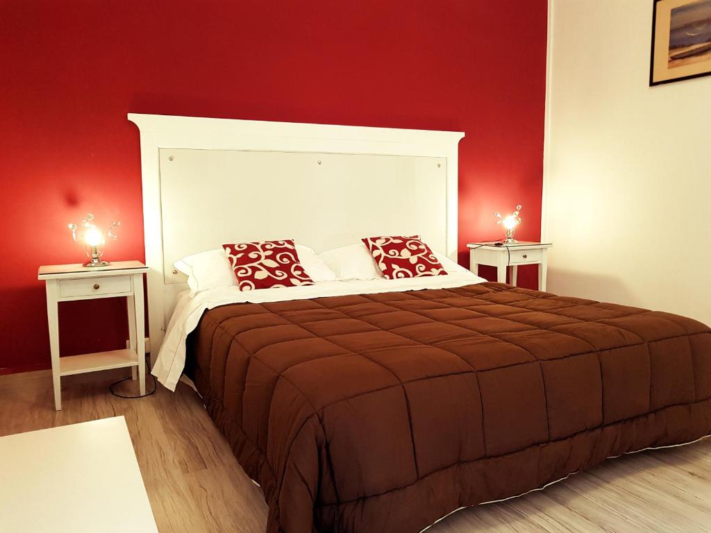 una camera da letto con un grande letto con pareti rosse di Oberdan a Catania