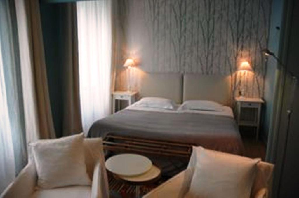カンペールにあるQuimper-Appartのベッドとソファ付きのホテルルーム