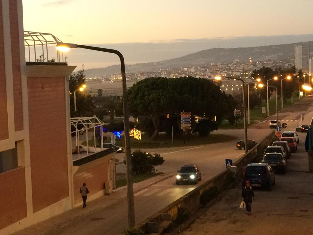 una strada di città di notte con auto parcheggiate sulla strada di Green Wave Hostel a Figueira da Foz