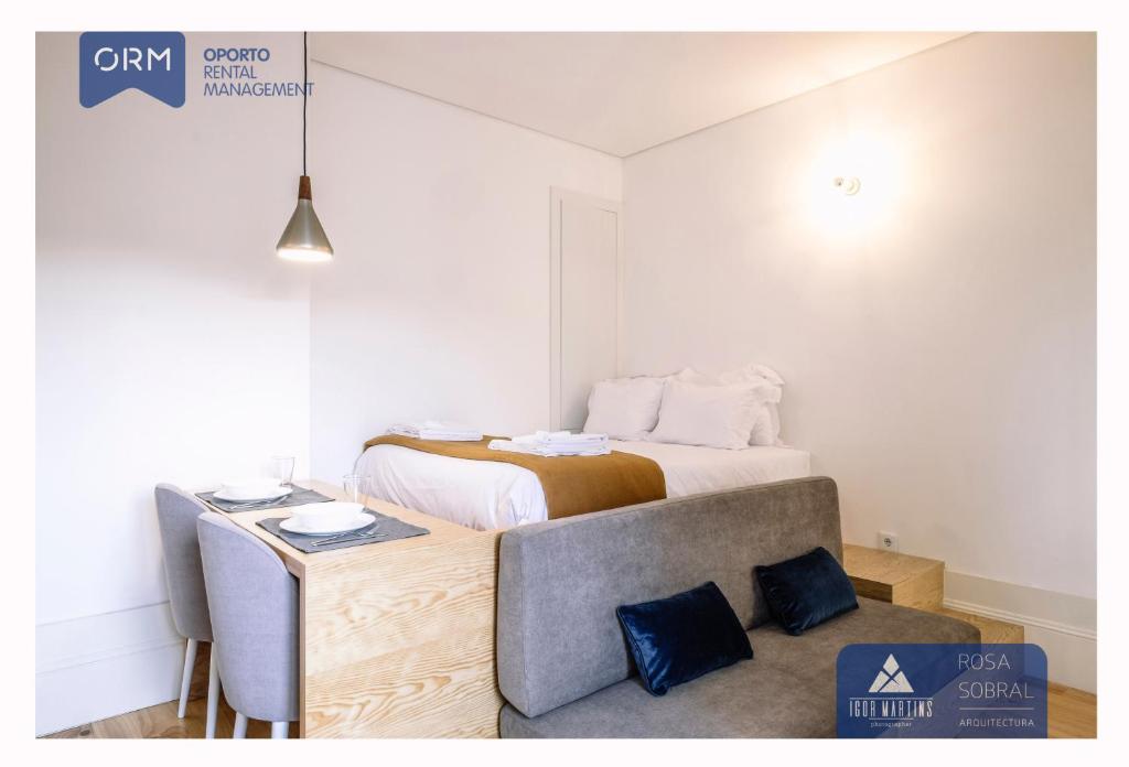 a bedroom with a bed and a table with a chair at ORM - 3 C´s Apartments in Porto