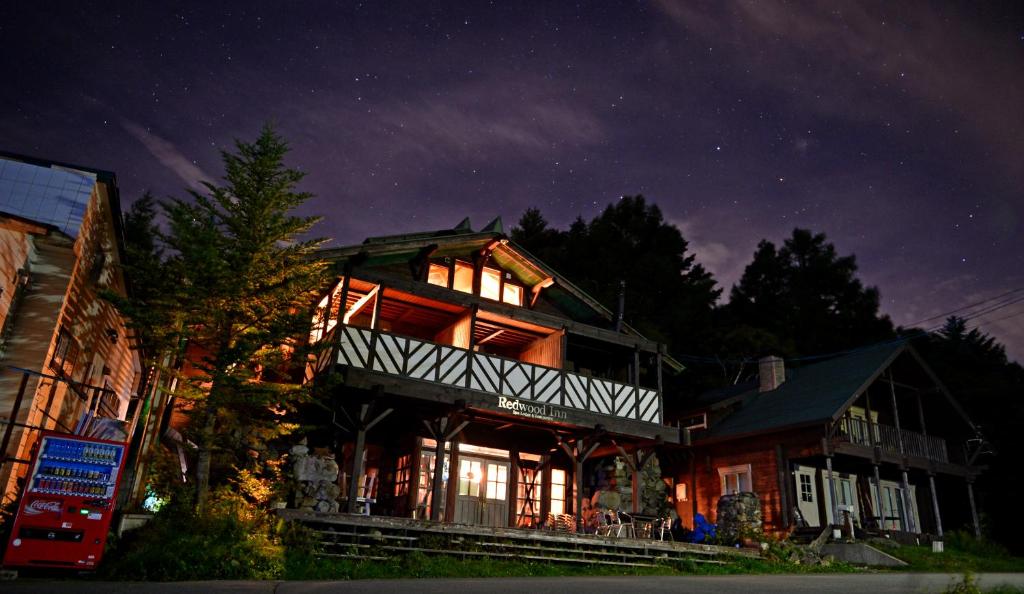 een groot huis 's nachts met de lichten aan bij Spa Lodge Redwood Inn in Takayama