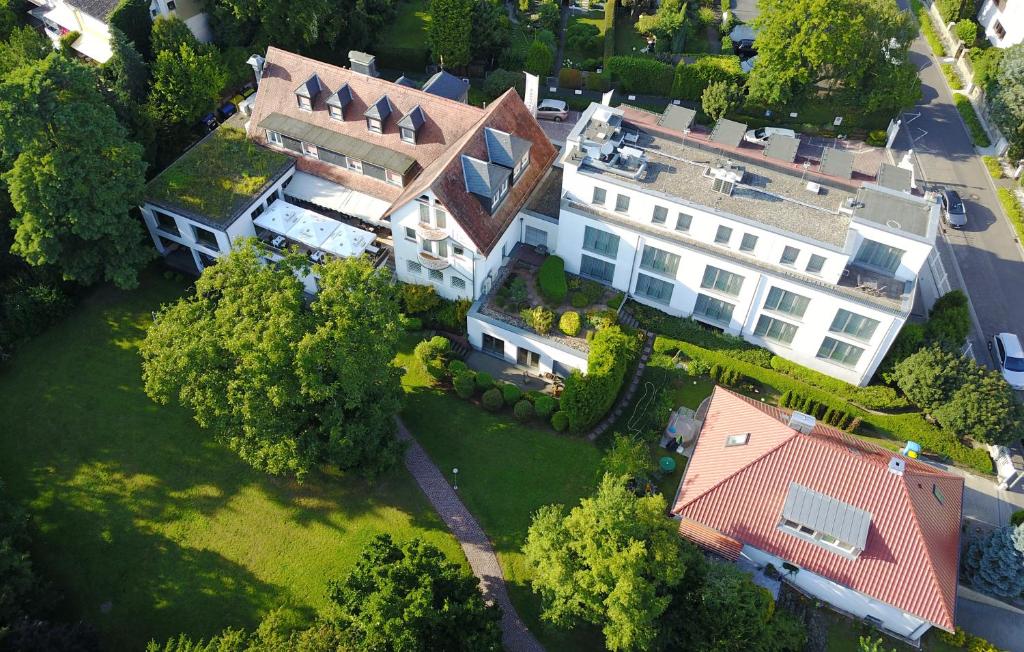 Elle offre une vue sur une grande maison avec une cour. dans l'établissement Hotel Birkenhof, à Hanau