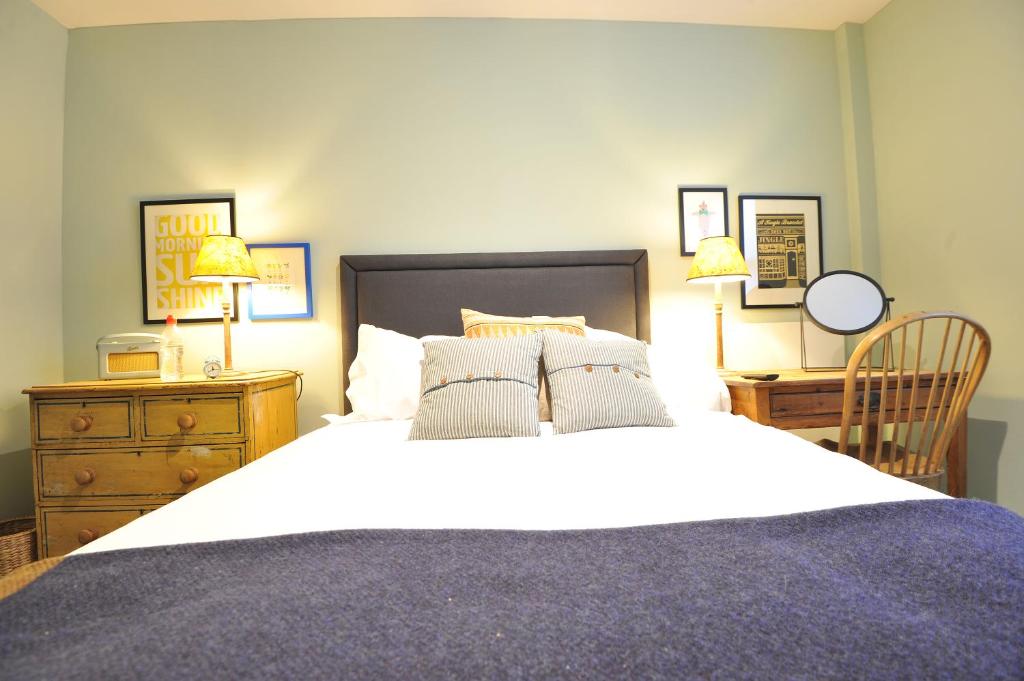 a bedroom with a large bed and a wooden dresser at The Narrowboat in Reading
