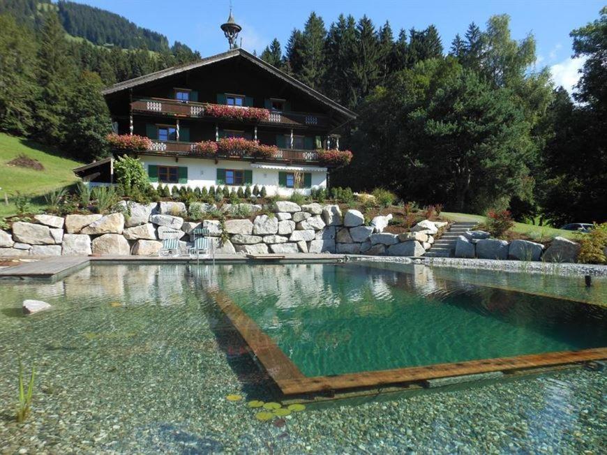 a large swimming pool in front of a house at Haus Waldhof in Brixen im Thale