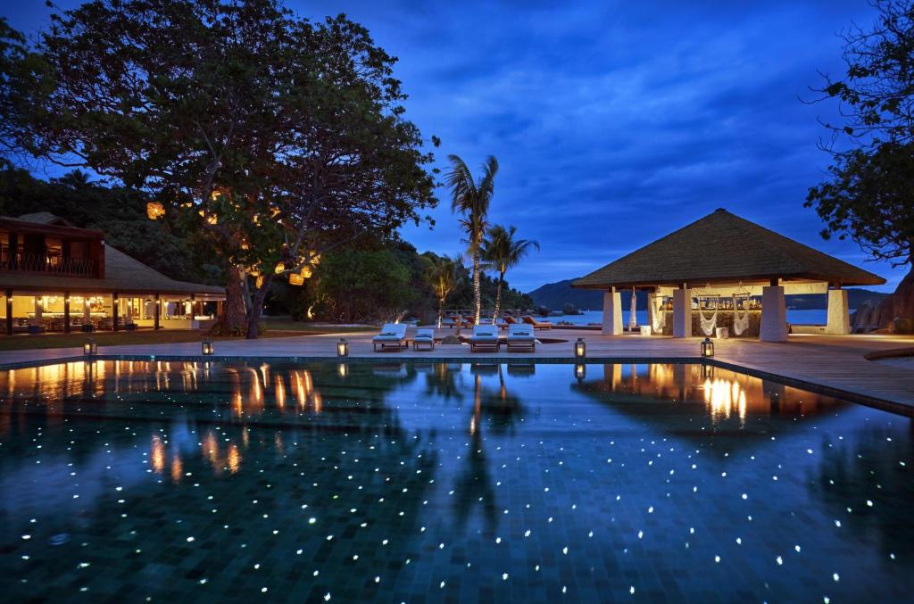 ein Pool in der Nacht mit Lichtern im Wasser in der Unterkunft Six Senses Zil Pasyon, Seychelles in Felicité