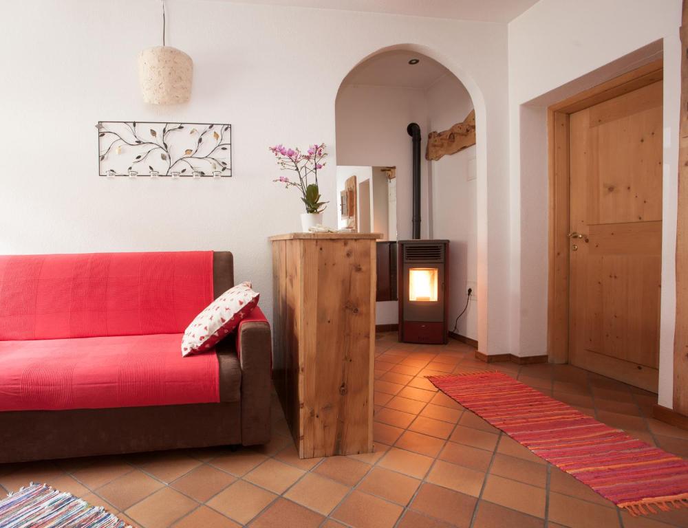 een woonkamer met een rode bank en een tafel bij Casa Melide 3 in Bormio