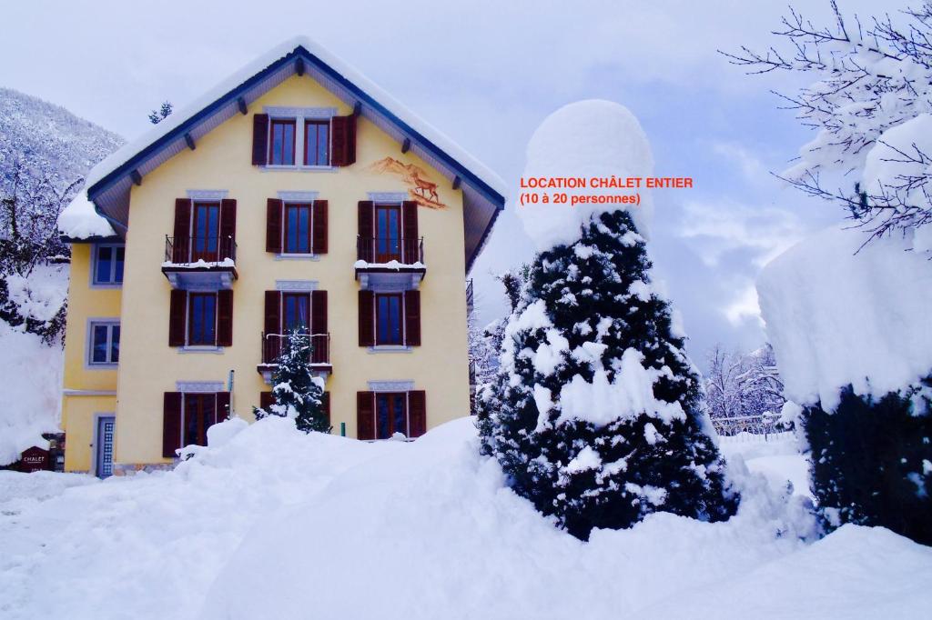 ブリッド・レ・バンにあるLe Chalet Jolyの雪に覆われた木が目の前にある家