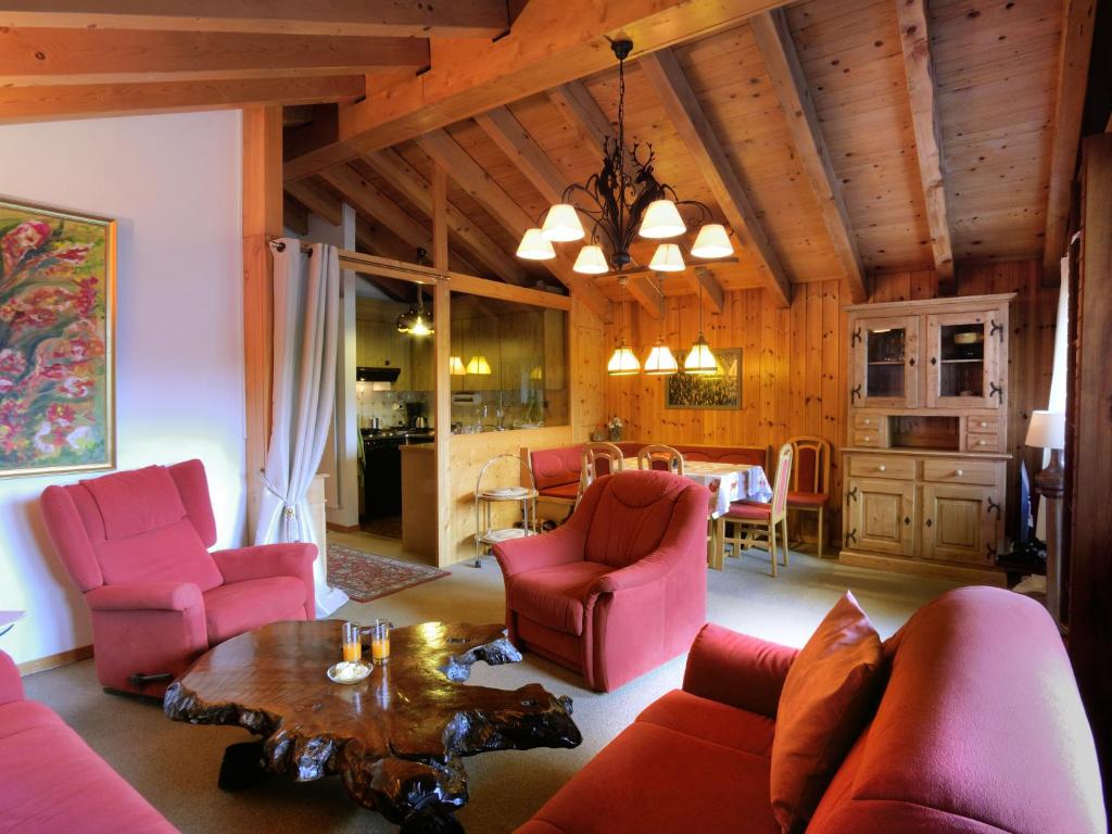 sala de estar con sillas rosas y mesa en Cosy 3.5 pièce à Täsch, en Täsch