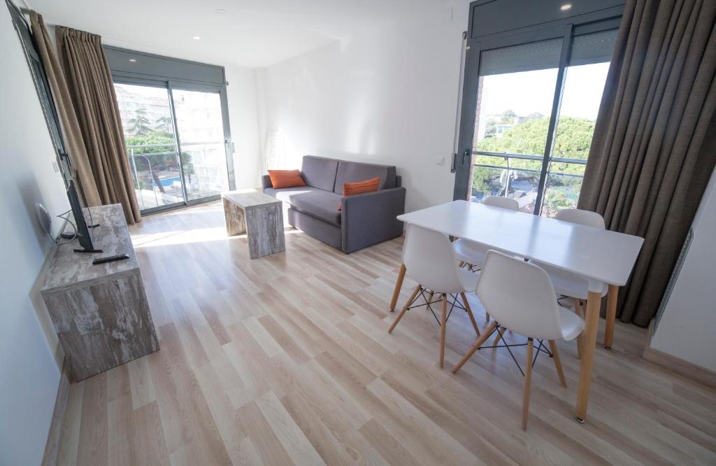 uma sala de estar com uma mesa branca e cadeiras em Apartaments Ponent em Lloret de Mar