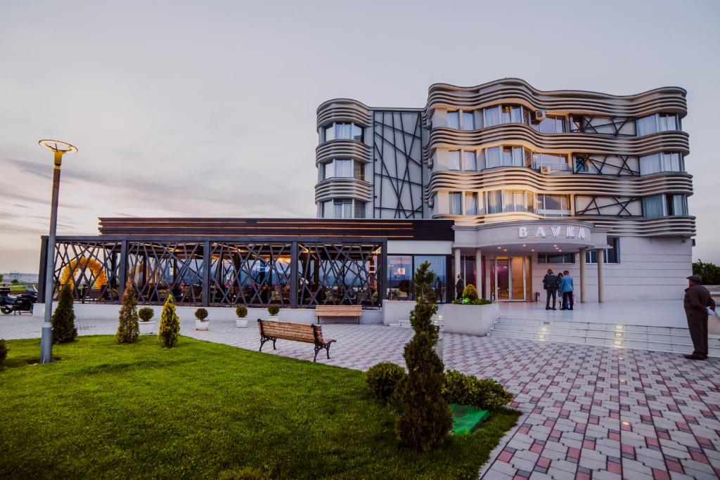 ein Gebäude mit einer Bank davor in der Unterkunft Hotel Bavka in Leskovac