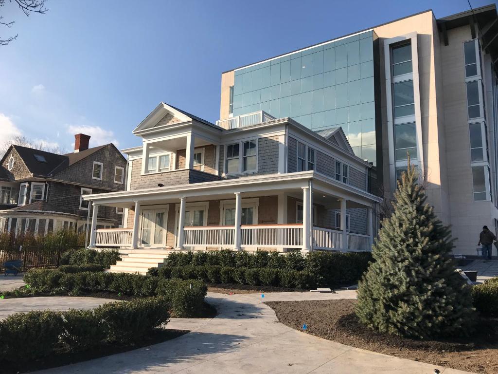 una grande casa con un edificio in vetro accanto ad essa di The Preston House and Hotel a Riverhead