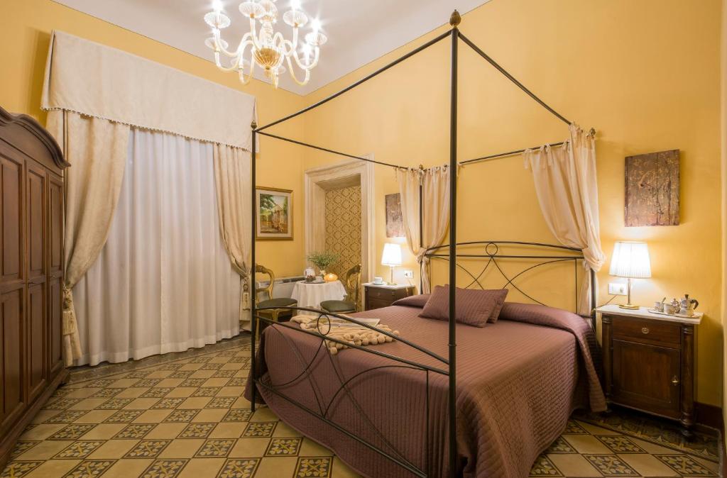 a bedroom with a canopy bed with a chandelier at La Bohème in Lucca