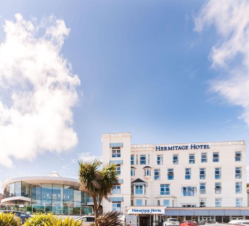 un edificio de hotel con una palmera delante en The Hermitage Hotel - OCEANA COLLECTION en Bournemouth