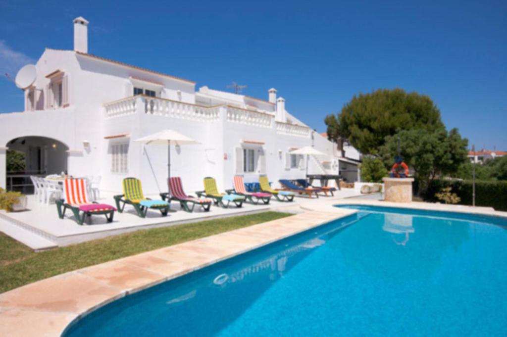 a villa with a swimming pool in front of a house at Villa Savanna in Cala en Blanes