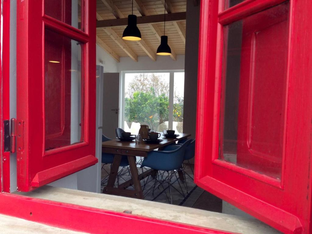 セルカルにあるvillage loftの赤いドア、テーブル、椅子が備わるお部屋