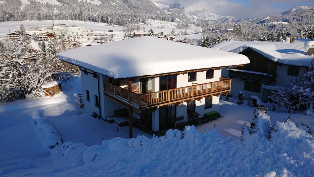 ein schneebedecktes Haus mit schneebedeckten Dächern in der Unterkunft Chalet France in Fieberbrunn