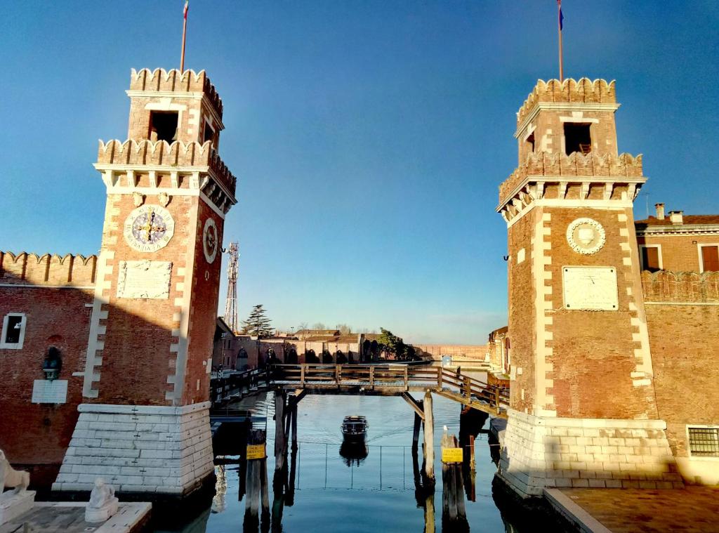 zwei Türme mit Uhren an einem Wasserkörper in der Unterkunft San Giorgio degli Schiavoni in Venedig