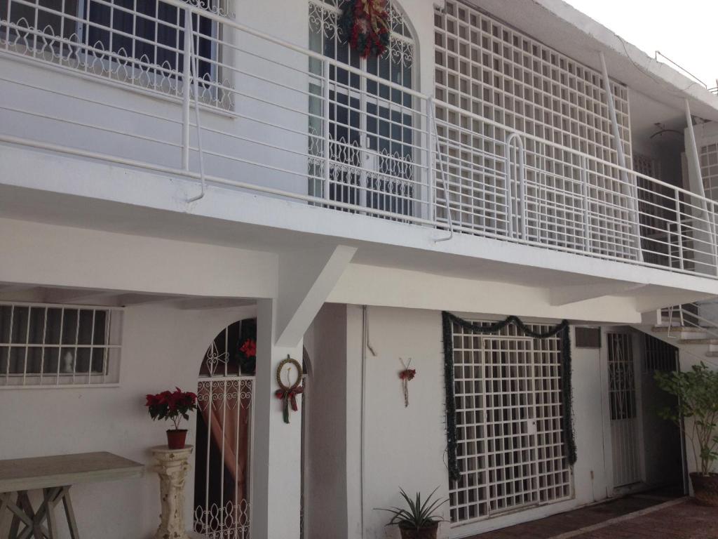 Casa blanca con balcón en la parte superior. en Casa Bocoyna en Acapulco