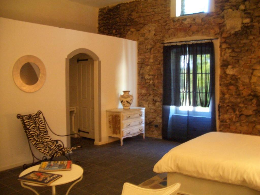 a bedroom with a bed and a dresser and a blue door at Le Prieuré des Sources in La Répara