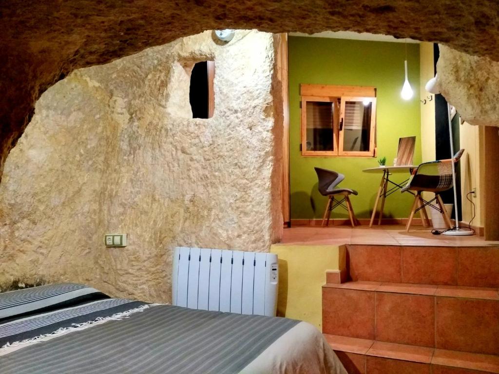 ein Schlafzimmer mit einem Bett und einer Felswand in der Unterkunft monmossen bocairent in Bocairent