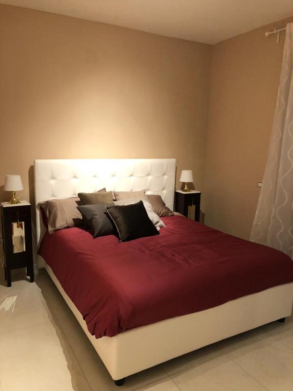 1 dormitorio con 1 cama grande con sábanas y almohadas rojas en B&b Panoramica 33 en Salerno