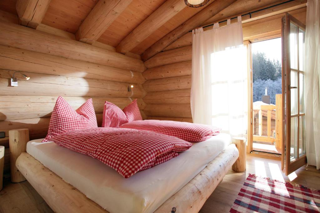 ein Schlafzimmer mit einem Bett in einer Blockhütte in der Unterkunft Blockhaus Chalet Heim in Kirchberg in Tirol