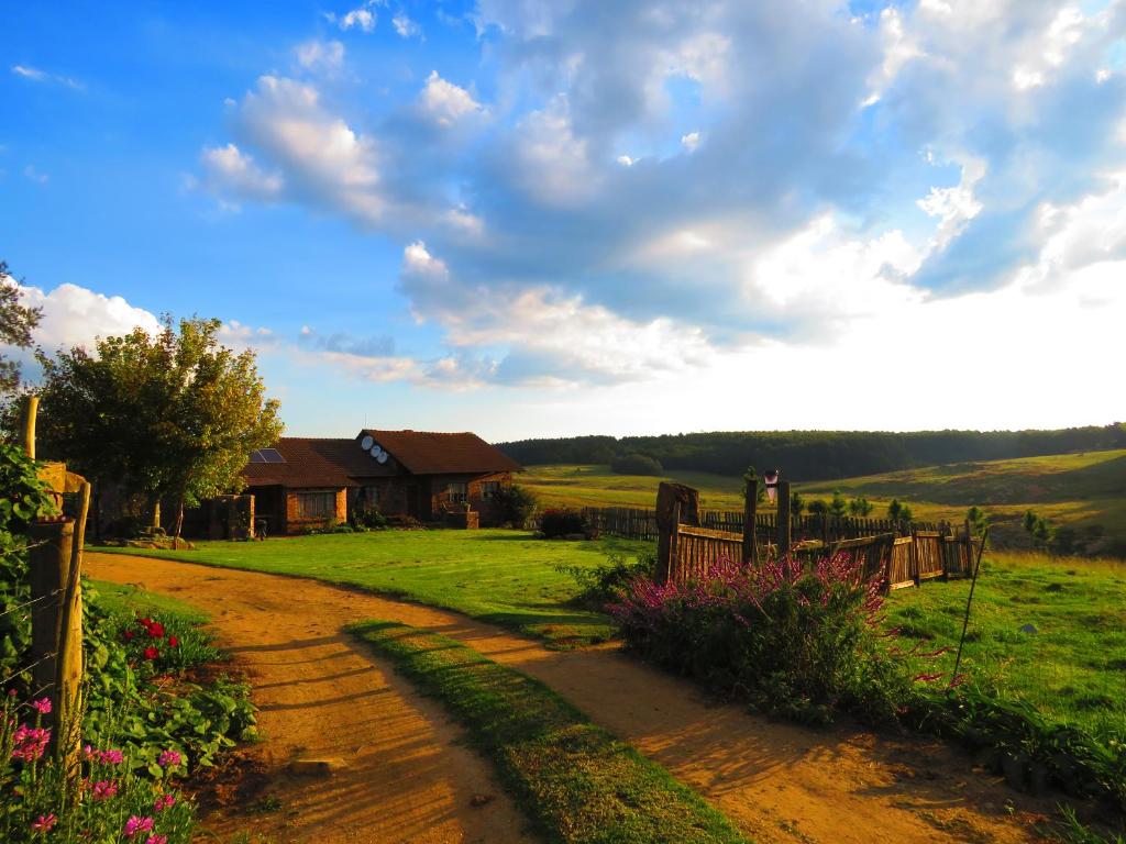 a dirt road leading to a house in a field at Rocks & Roses Farm stay in Lochiel