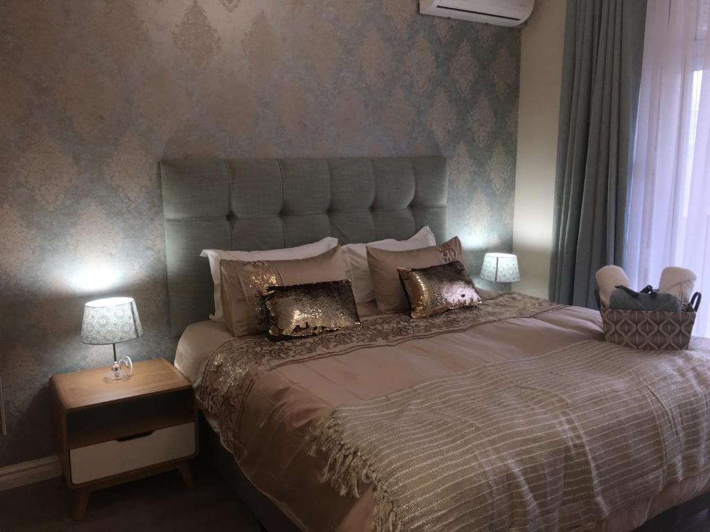 a bedroom with a large bed with a large headboard at AYA LUXURY APARTMENTS 78 in Durban