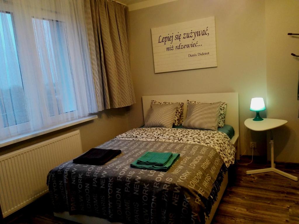 a small bedroom with a bed and a window at Grey Apartament Centrum Gdynia in Gdynia