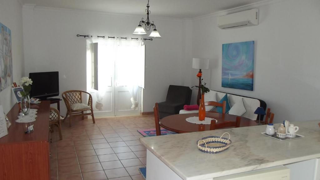 cocina y sala de estar con mesa en Family Floripes House, en Olhão