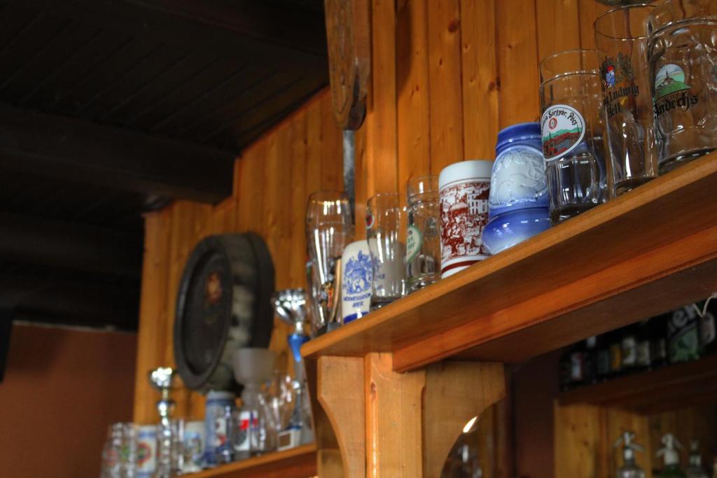 a shelf with glasses and other items on it at Gilde étterem és panzió in Pilisvörösvár