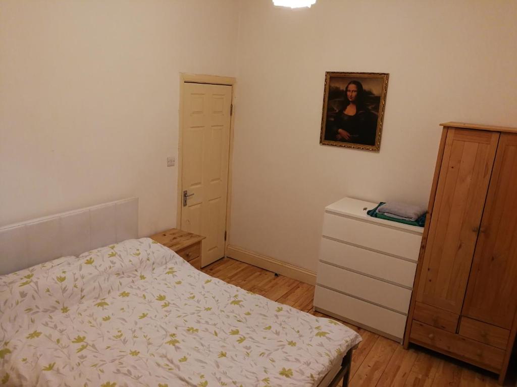 een kleine slaapkamer met een bed en een dressoir bij Haringey Victorian House in Londen