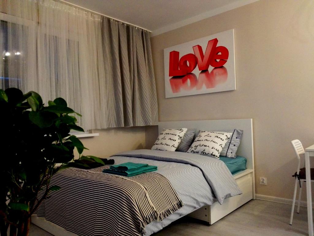 グディニャにあるVanilly Apartament Centrum Gdyniaのベッドルーム1室(壁にラブサイン付きのベッド1台付)