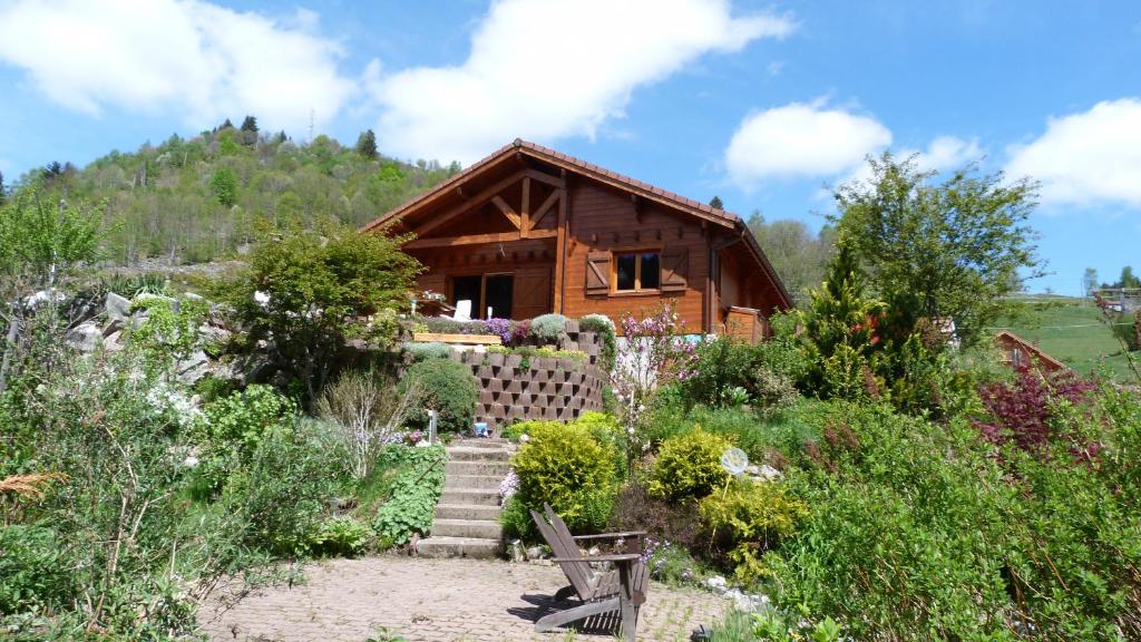 a log cabin with a garden in front of it at Chalet Notre Retraite in Ventron