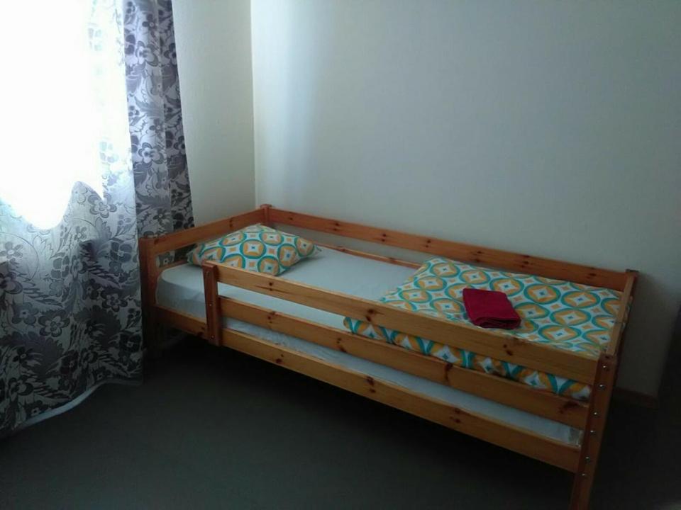 un letto in legno in una camera con finestra di Brīvdienu māja 1 a Kurmēni