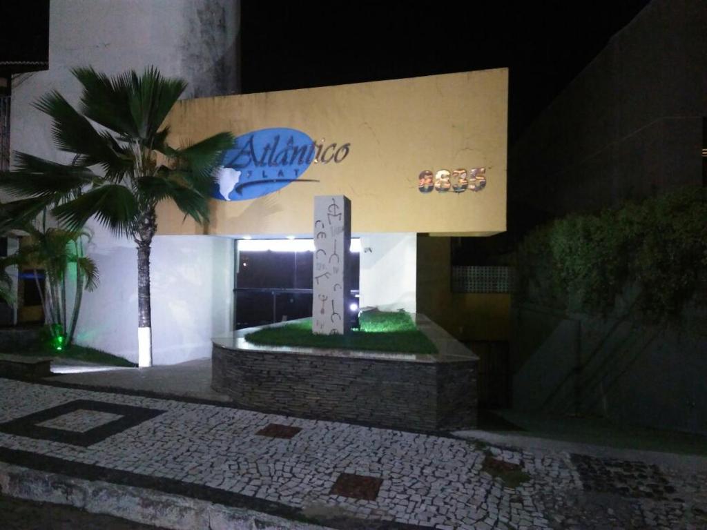 aania Schild vor einem Gebäude mit einer Palme in der Unterkunft Atlântico Flat 110 in Natal